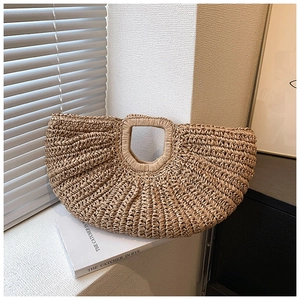 Close-up of beige handmade straw bag showing intricate woven texture and hollow handle