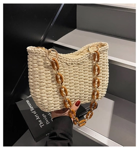 Detail of hand-woven straw shoulder bag featuring amber acrylic chain and wavy edge