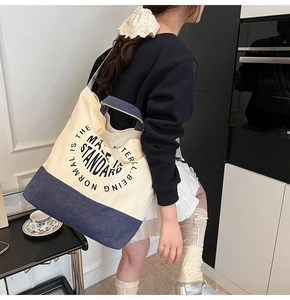 Détail du grand sac cabas en toile avec imprimé lettres et design patchwork en denim