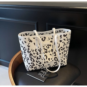 Detail van witte tote bag met zwarte stippenprint met handvatten en premium kunstleer textuur