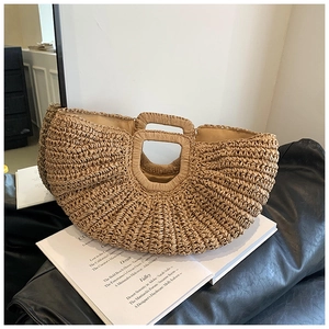 Detail of handmade straw tote bag with integrated handles and woven texture for summer