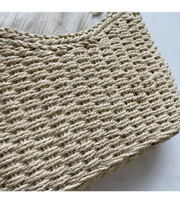 Detailed macro view showing the tight woven texture of natural straw fiber beach bag