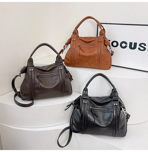 Three vintage motorcycle bags in brown, coffee, and black with woven trim and rivets