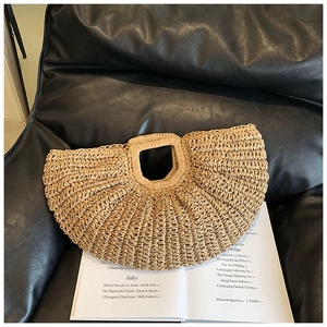 Close-up of fan-shaped handmade straw handbag featuring natural woven texture and round handle