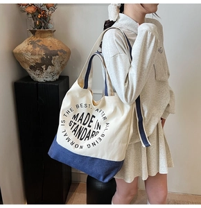Détail du grand sac cabas en toile avec des lettres imprimées contrastées en bleu marine