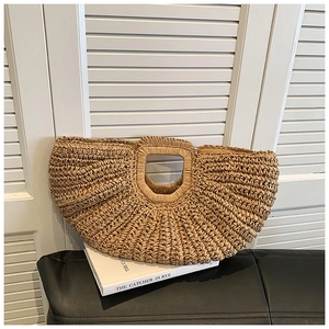 Detail of a semi-circular straw bag with textured horizontal weave and top handle