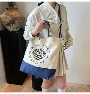 Détail du sac fourre-tout en toile bicolore crème et marine avec imprimé graphique