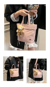 Pink pleated canvas tote bag detail with logo and cute teddy bear charm accessory