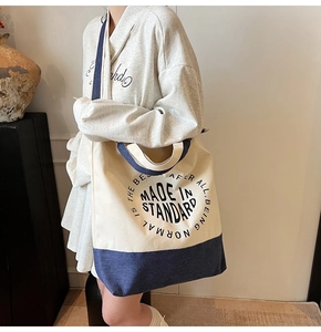 Détail d'un grand sac cabas en toile avec bordure denim contrastée et imprimé slogan