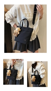 Detail of black nylon tote bag with wide shoulder strap and brown plush bear charm
