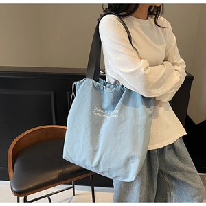 Detail of light blue canvas tote bag featuring white dream together printed slogan