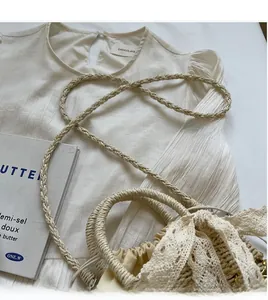 Vue détaillée du sac seau en paille avec nœud en dentelle et haut plissé blanc