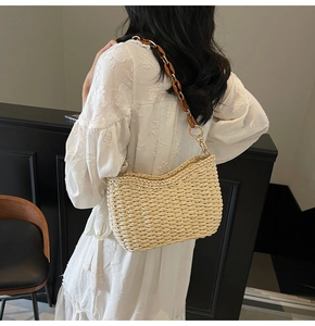 Detail of hand-woven straw shoulder bag with stylish brown tortoiseshell acrylic chain strap