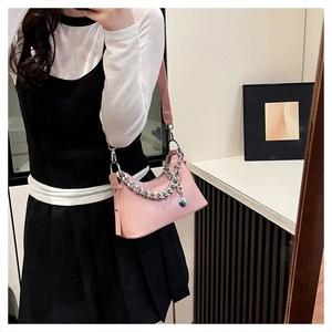 Detailed shot of pink glossy shoulder bag with chunky silver chain and metal pendant