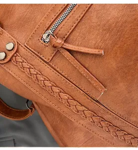 Close-up of brown textured leather tote featuring smooth silver hardware and woven details