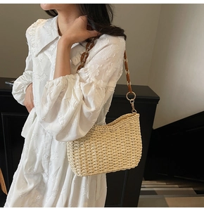 Dettaglio borsa a tracolla in paglia beige con catena in resina marrone e trama intrecciata