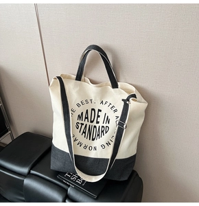 Détail de la bandoulière réglable avec boucle en métal sur un sac cabas en toile