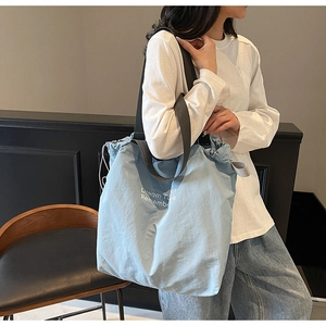 Detail of light blue canvas tote bag featuring Dream Time drawstring and black nylon strap
