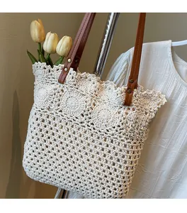 Dettaglio della borsa tote in maglia con manici in pelle marrone e rivetti