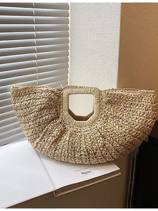 Minimalist straw half-moon tote bag with integrated handle for summer beach vacations