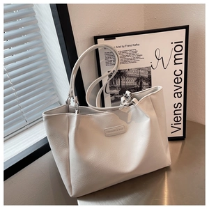 Close-up of white tote bag with lychee grain texture and FASHION & BAG label