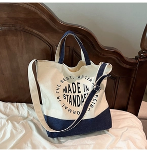 Détail du sac fourre-tout en toile avec fond en denim et boucle métallique ajustable