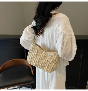 Detail of handmade straw shoulder bag with acrylic tortoiseshell chain and golden hardware
