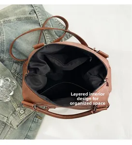 Detail view of large brown retro leather bag with internal compartments and zip pocket