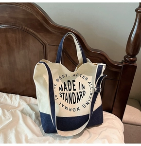 Détail du cabas en toile et denim avec slogan rond sur un fond intérieur chaleureux