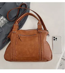 Detailed top view of a brown vintage tote bag with woven straps and metal rivets for daily use
