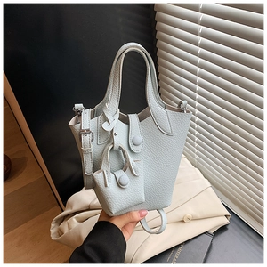 Close-up of light blue lychee pattern leather bucket bag with matching mini pouch charm