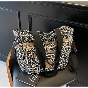 Close-up of leopard print tote bag with multiple zipper pockets and adjustable straps