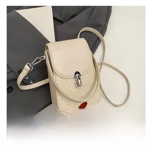 Detail of beige small crossbody bag with woven texture and silver metal twist lock