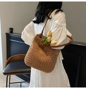Dettaglio di una borsa tote in maglia marrone con cinturini in pelle e motivi traforati