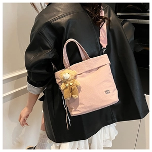 Pink canvas tote bag featuring a cute teddy bear pendant and wide shoulder strap