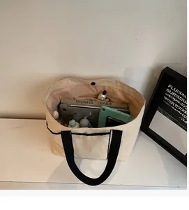 Interior view of large beige canvas tote bag showing laptop and tablet storage space