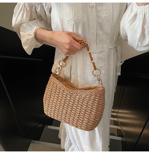 Detail of straw woven shoulder bag with resin chain strap and metal rings
