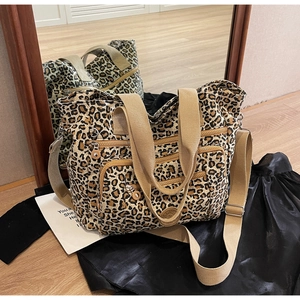 Macro shot of leopard print canvas tote with multi-pocket details and mirror reflection