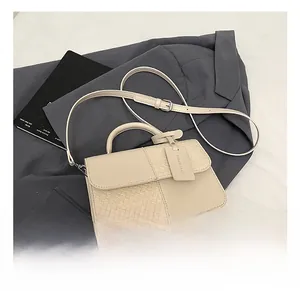 Détail du sac crème en cuir lisse avec un design en patchwork tissé et une bandoulière