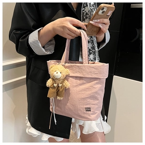 Detail of pink tote bag showing wrinkled texture fabric and cute bear pendant
