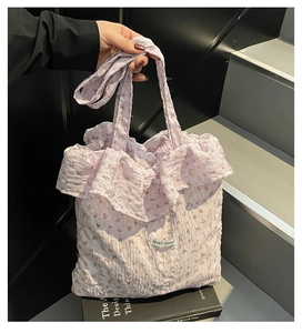 Detailed close-up of light purple floral tote bag with ruffle trim and textured fabric