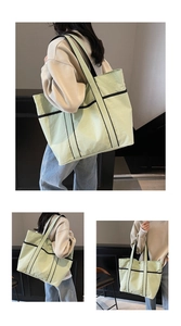 Detail of mint green tote bag with black straps and natural crinkle texture fabric