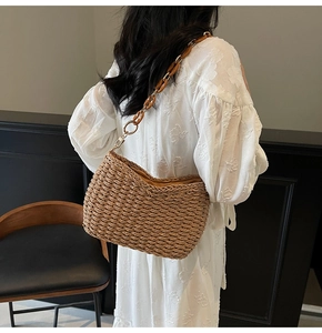 Detail of handmade straw shoulder bag with amber tortoiseshell chain and golden clasp