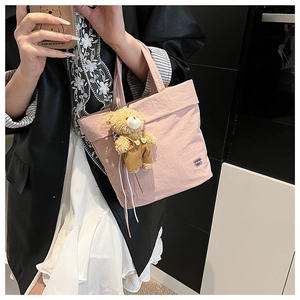 Mirror selfie showing a pink nylon tote bag with a cute bear plush toy charm