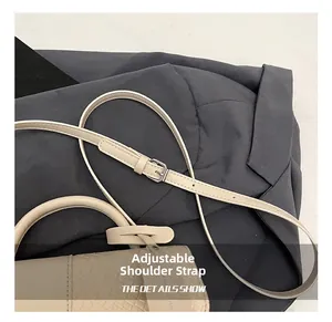 Détail de la bandoulière réglable avec boucle argentée sur le sac beige à texture tressée