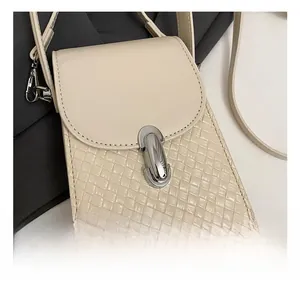 Close-up of creamy white woven texture bag with a polished silver metal twist lock