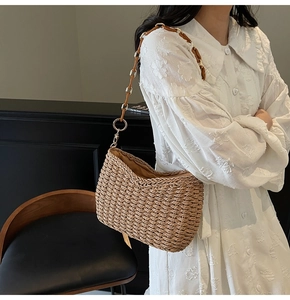 Detail of handmade straw shoulder bag with unique wood and gold metal chain link strap
