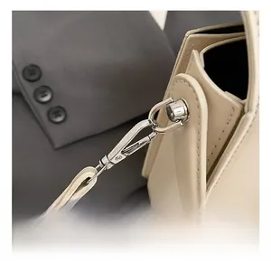 Detail of silver metal swivel hook and detachable strap on cream leather handbag