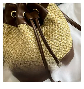 Detailed macro view of woven straw texture with brown leather drawstring and gold eyelets