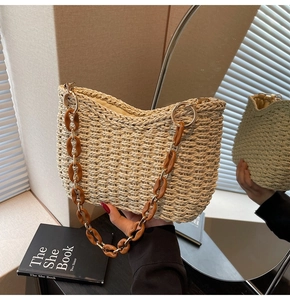 Detail of hand-woven straw bag with tortoiseshell acrylic chain strap in natural light
